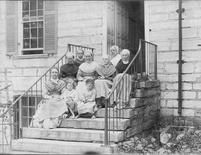 SA0210 - Seven women and two girls on steps by the side door of the Centre House. Identified on the reverse., Winterthur Shaker Photograph and Post Card Collection 1851 to 1921c